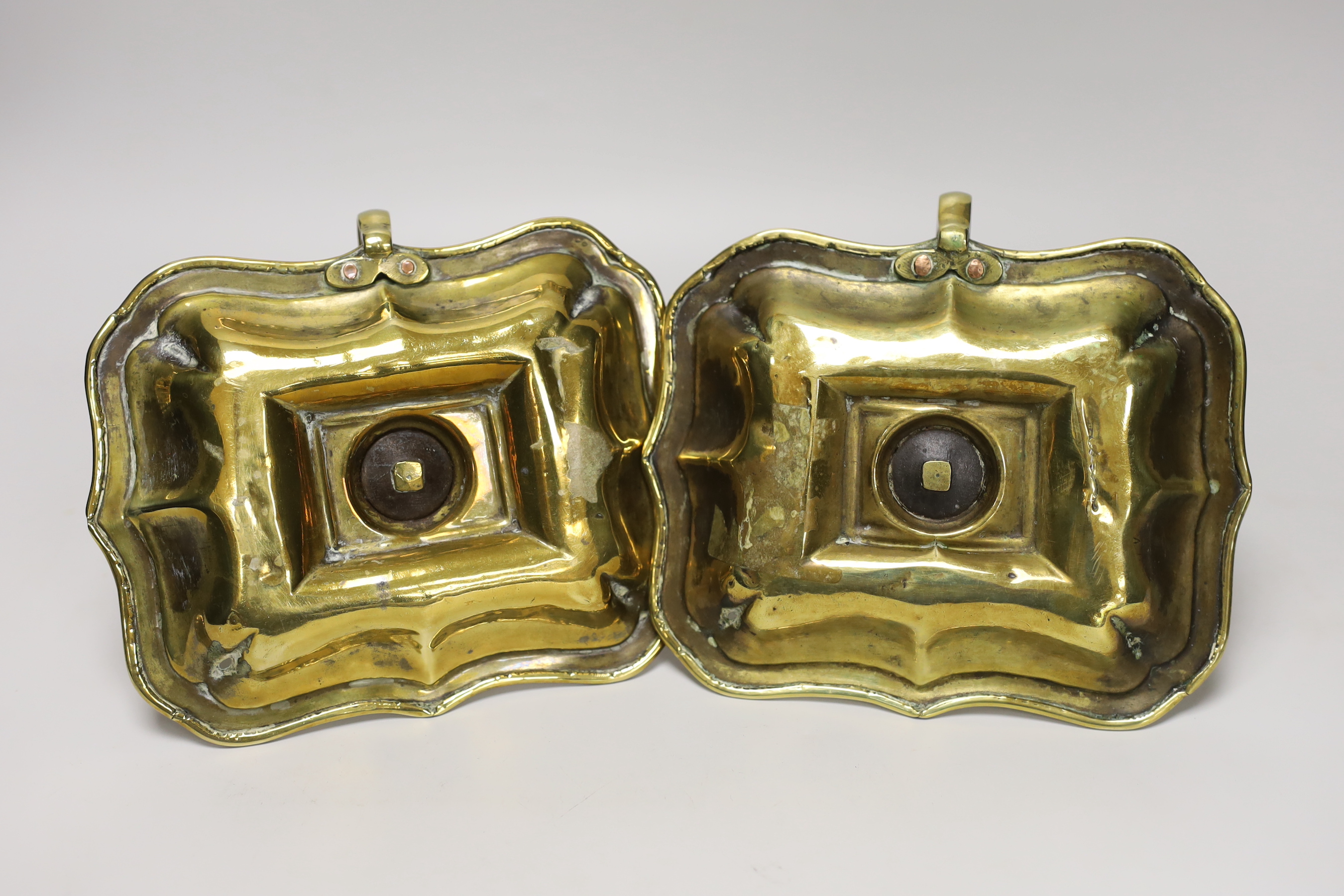 A pair of 18th century brass chamber candlesticks, the rectangular trays with wave edges, 18cm wide